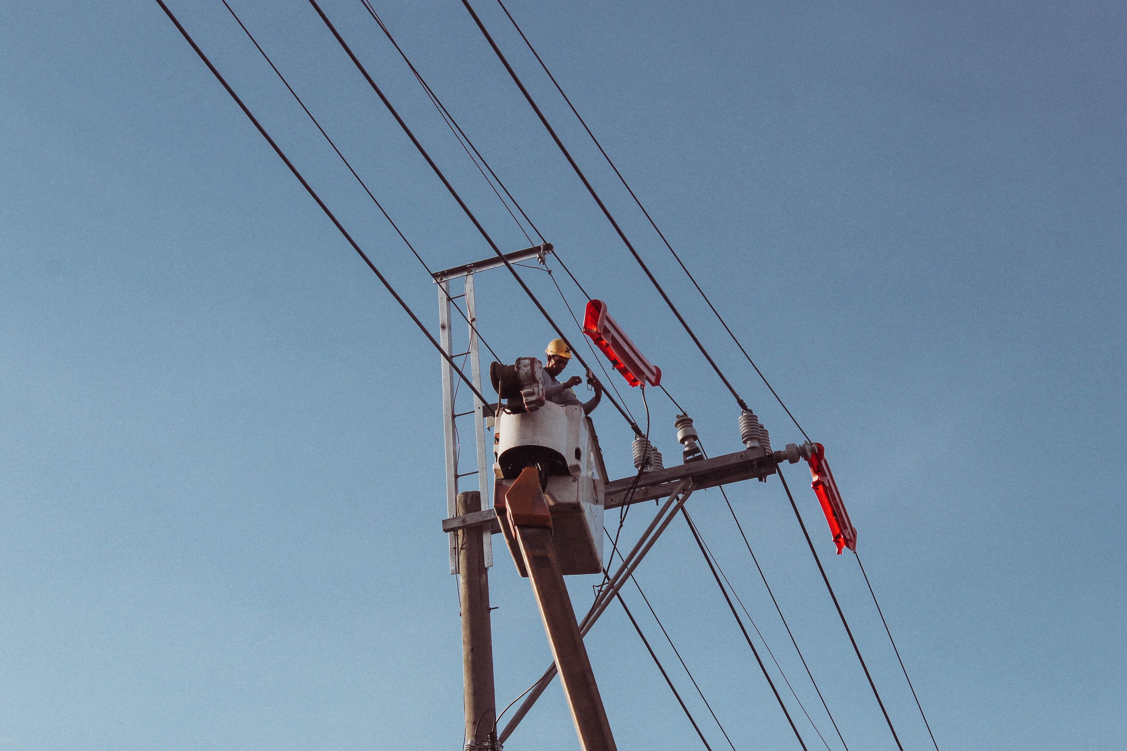 Engineer works on high power lines, ensuring electrical safety and maintenance.
