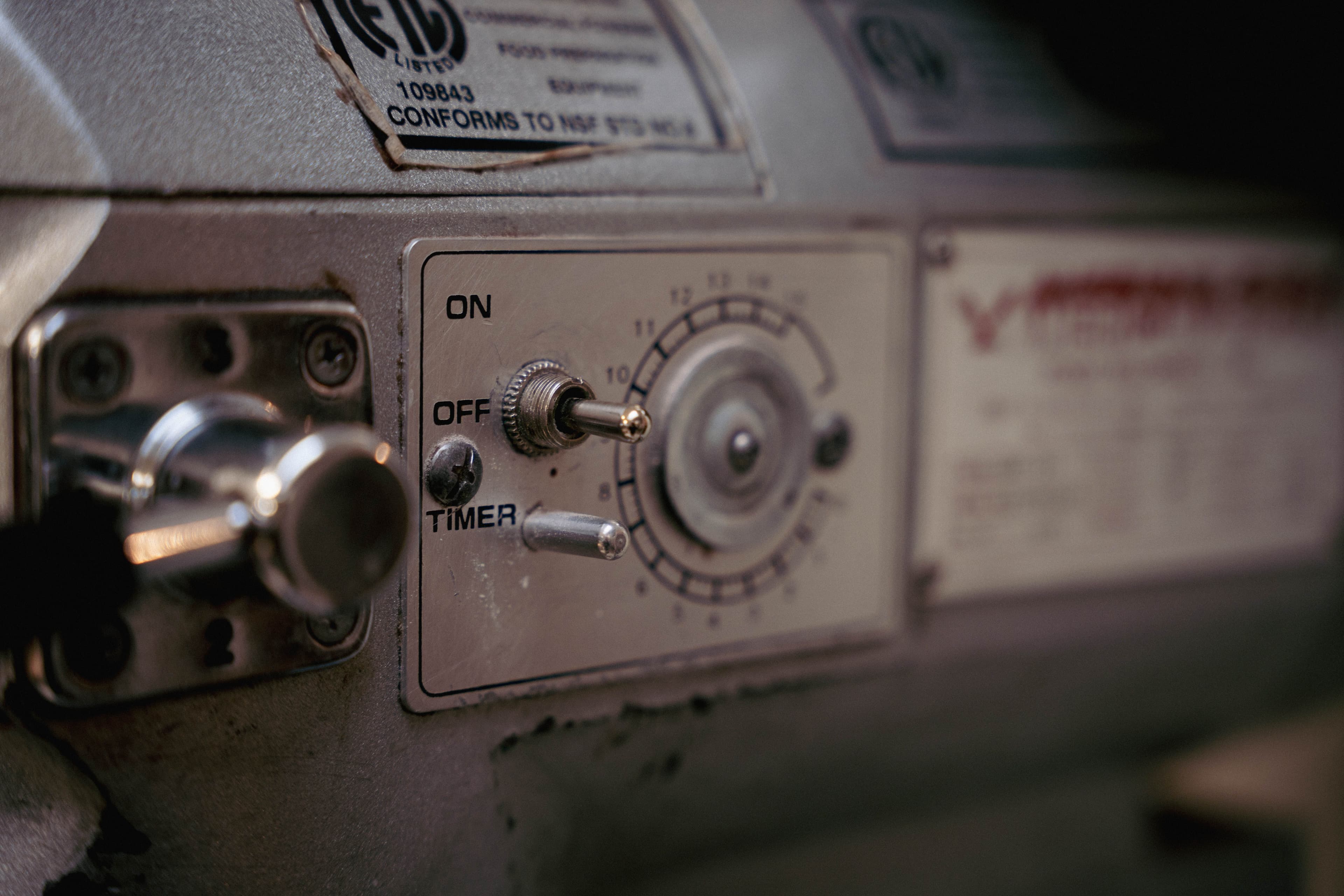 Detailed close-up of a vintage industrial machine control panel with knobs and switches.