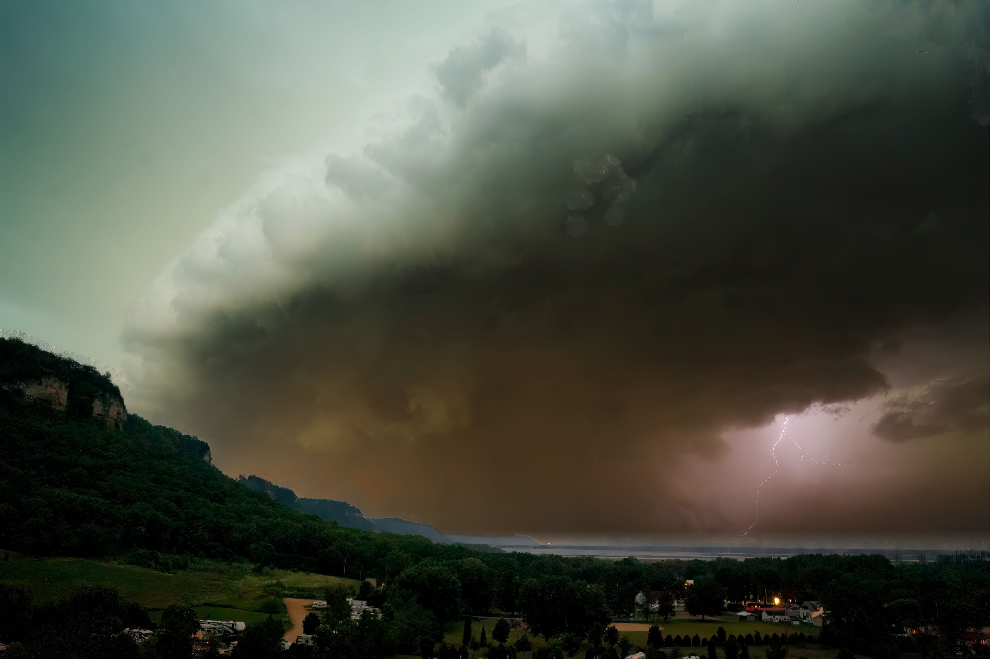A dramatic lightning storm over Nelson, WI, showcasing a massive cloud formation and vibrant landscape.