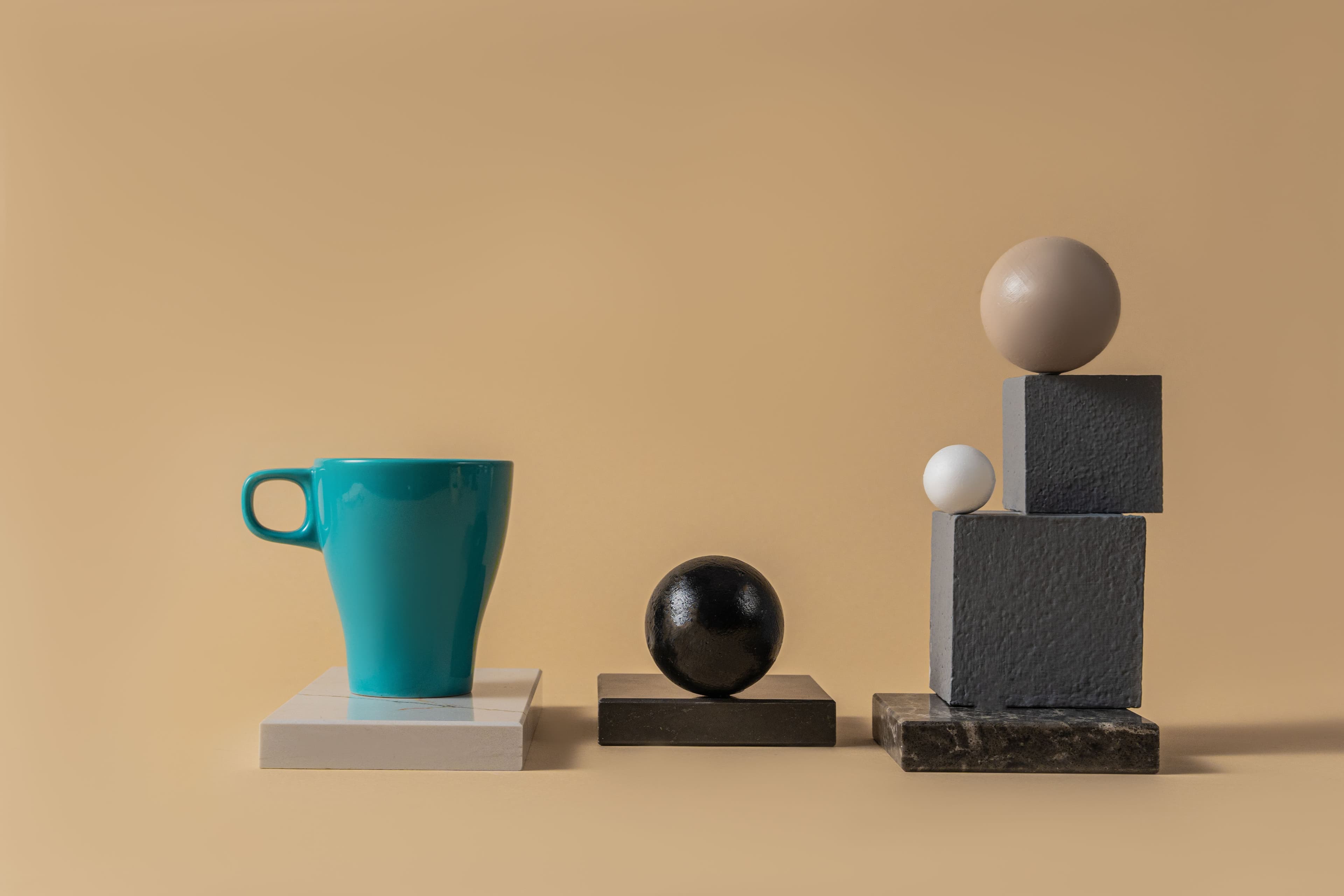 Abstract, modern composition of mugs, spheres, and blocks with neutral tones.