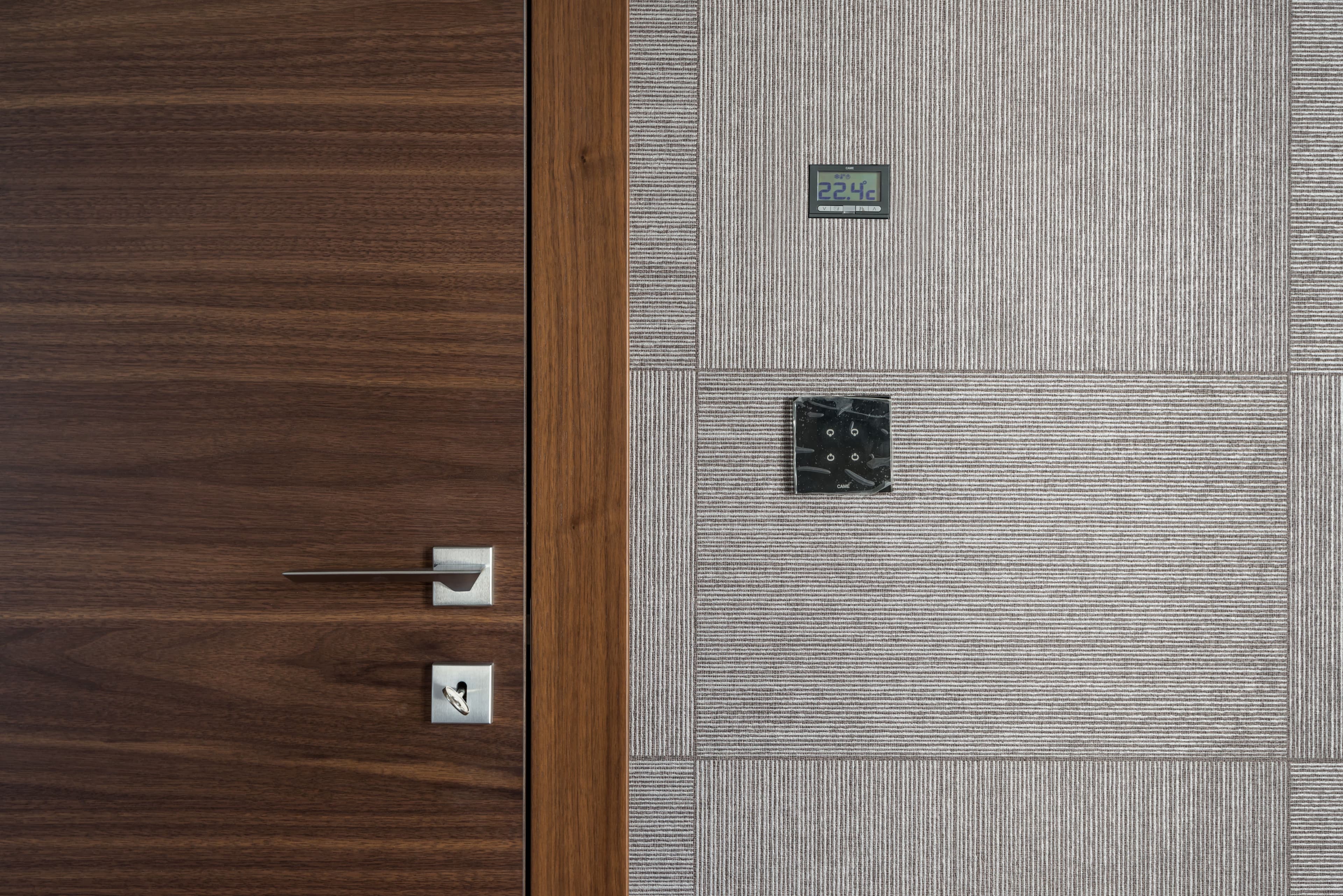 Sleek modern wooden door with stainless steel handle and 22.4°C display.