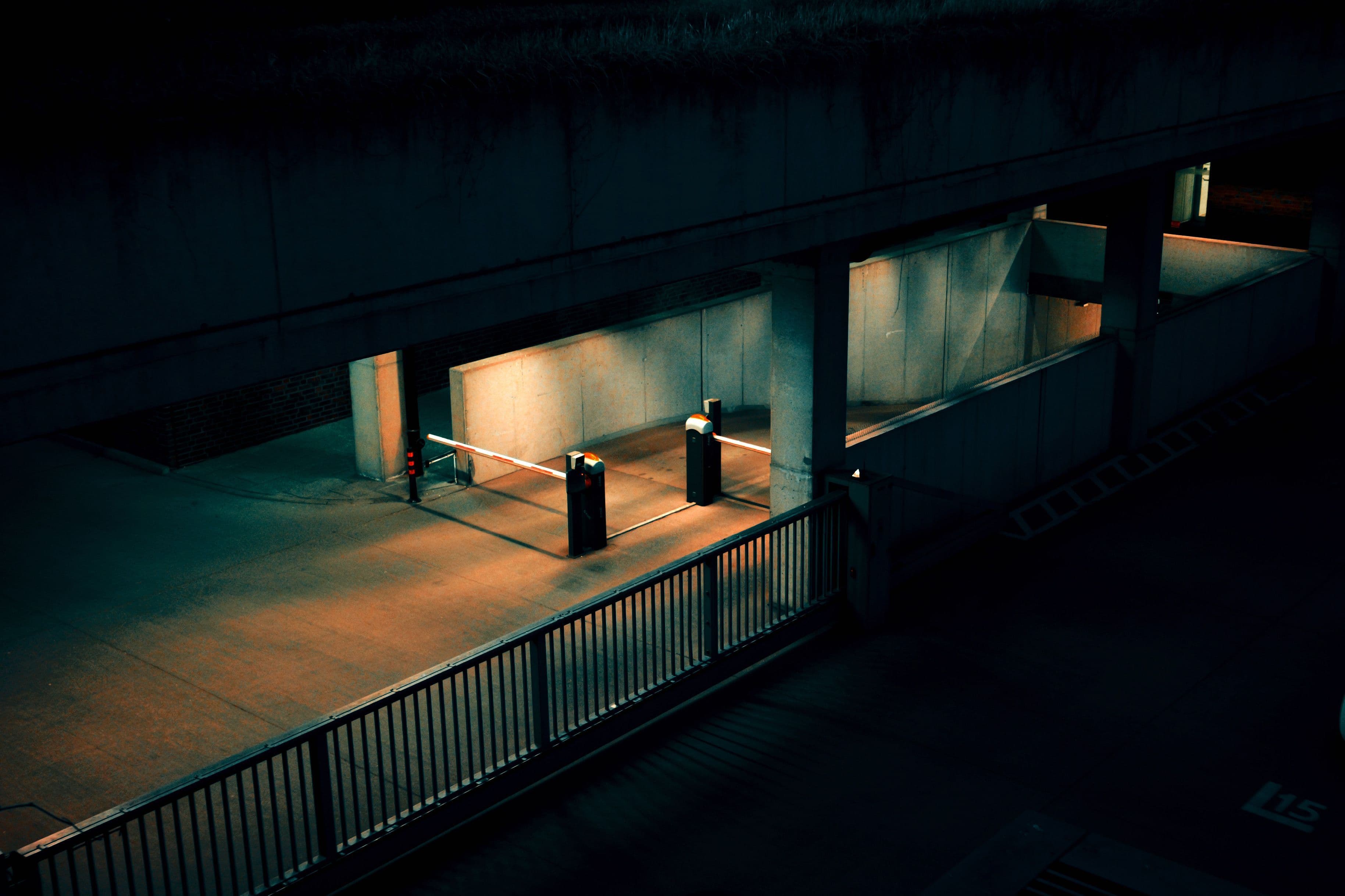 Moody view of an empty parking garage entrance lit by streetlights at night.
