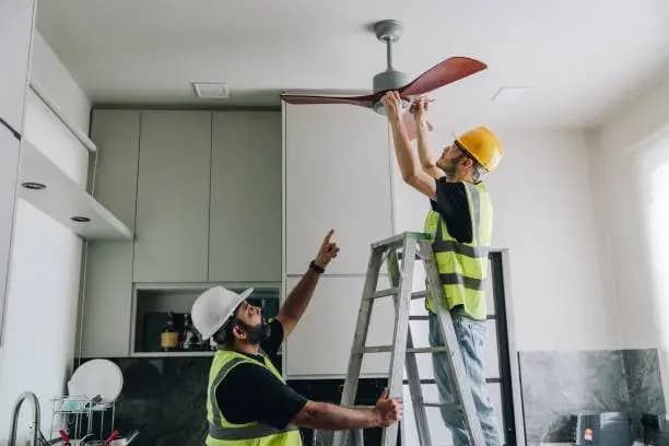Technician Inspecting Ceiling Fan Installation.