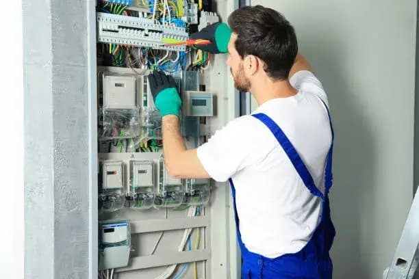 Technician examining a detailed breaker box diagram for troubleshooting electrical issues.